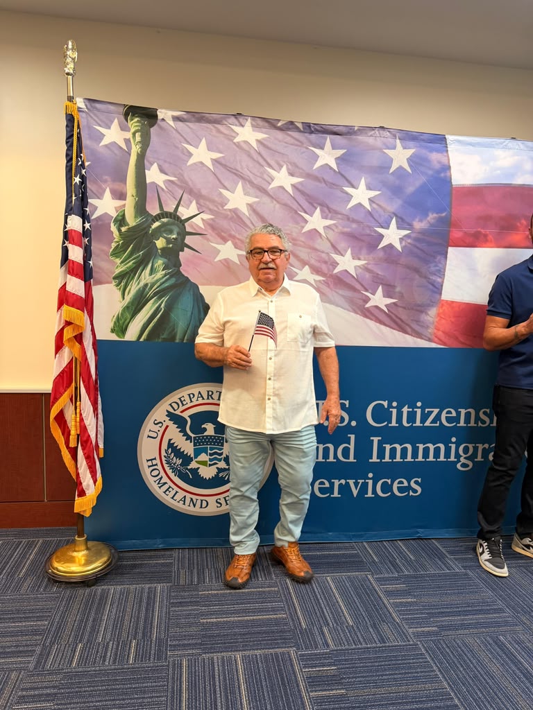 Wilson Almeida com a bandeira americana após a cerimônia de naturalização